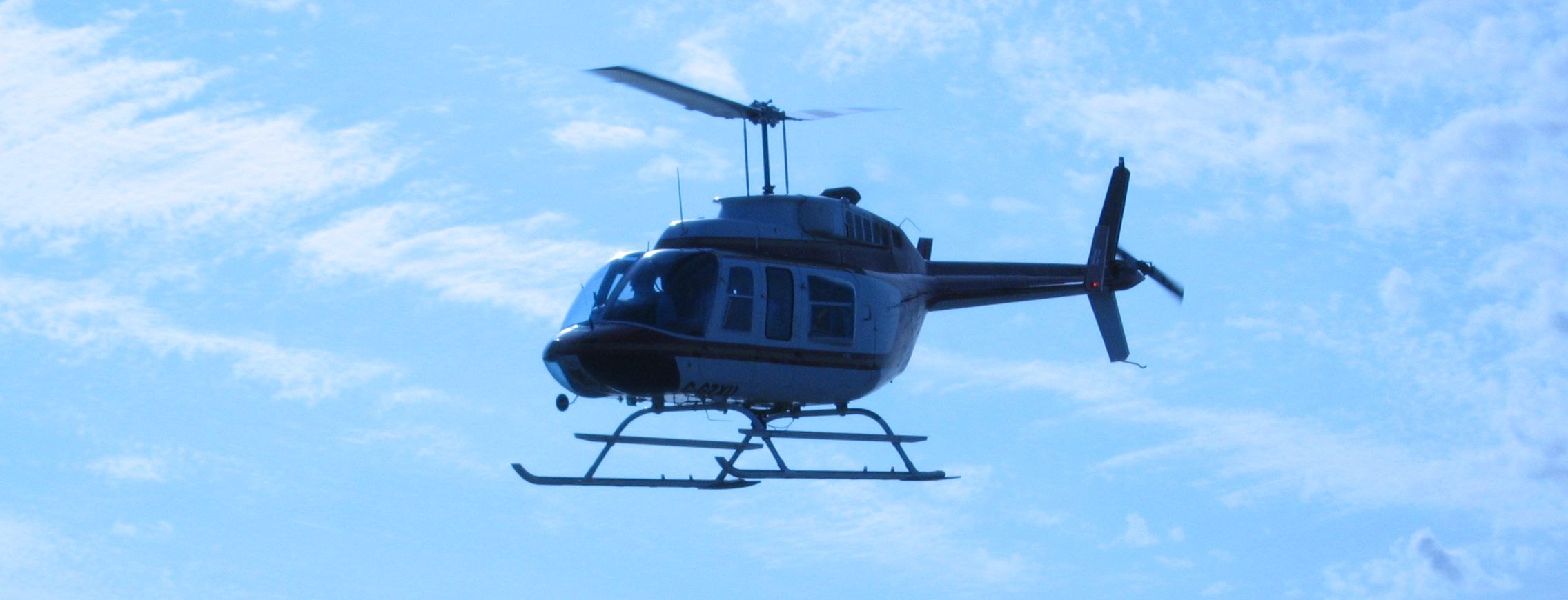 Bell 206 in dark blue livery in flight