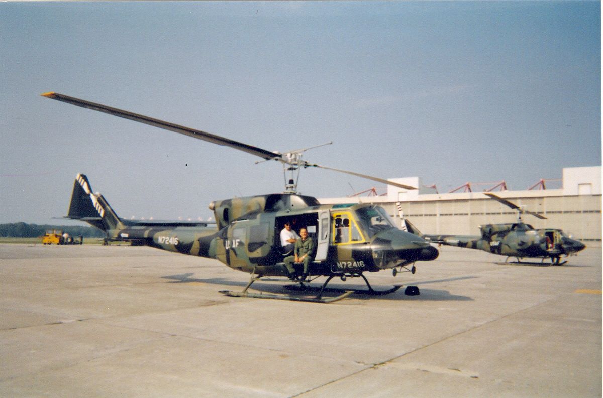Utility helicopter in military camouflage livery on a ramp