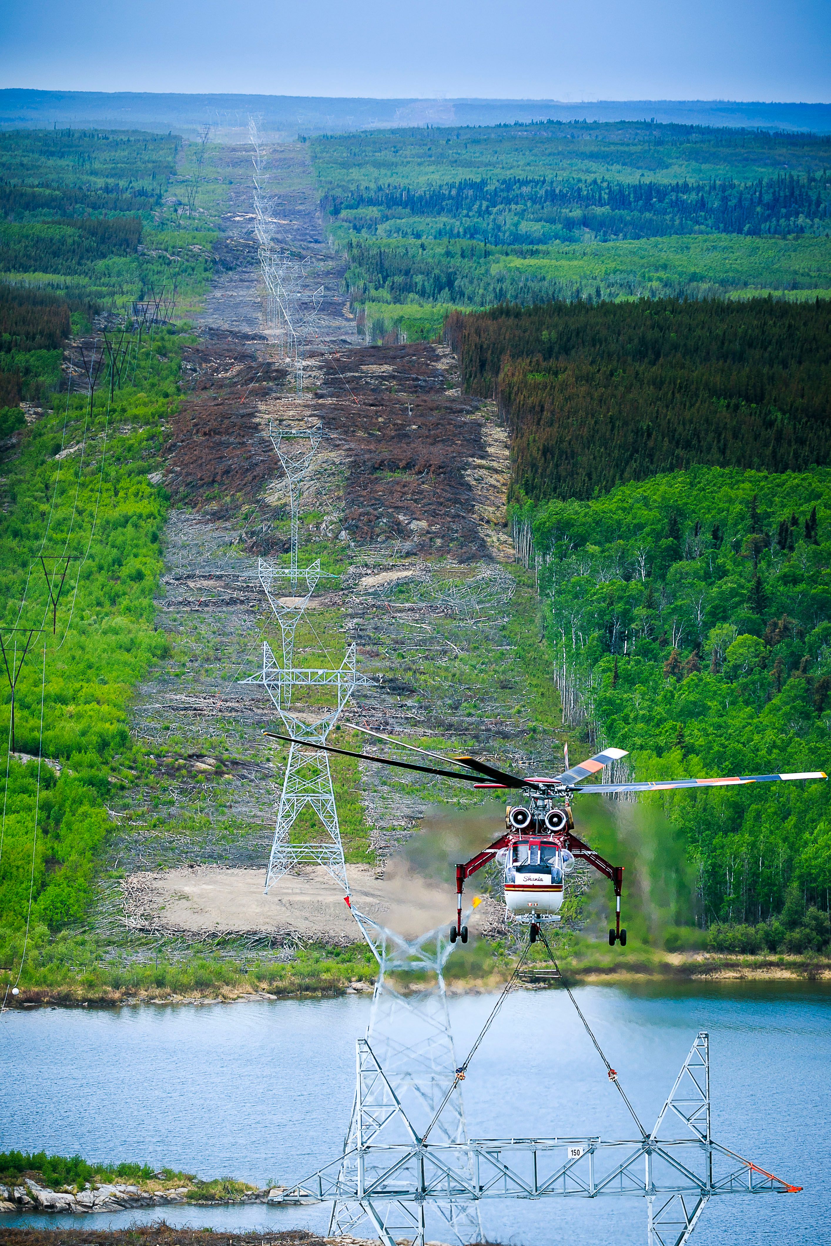 Transmission tower section lowered onto a cleared right-of-way