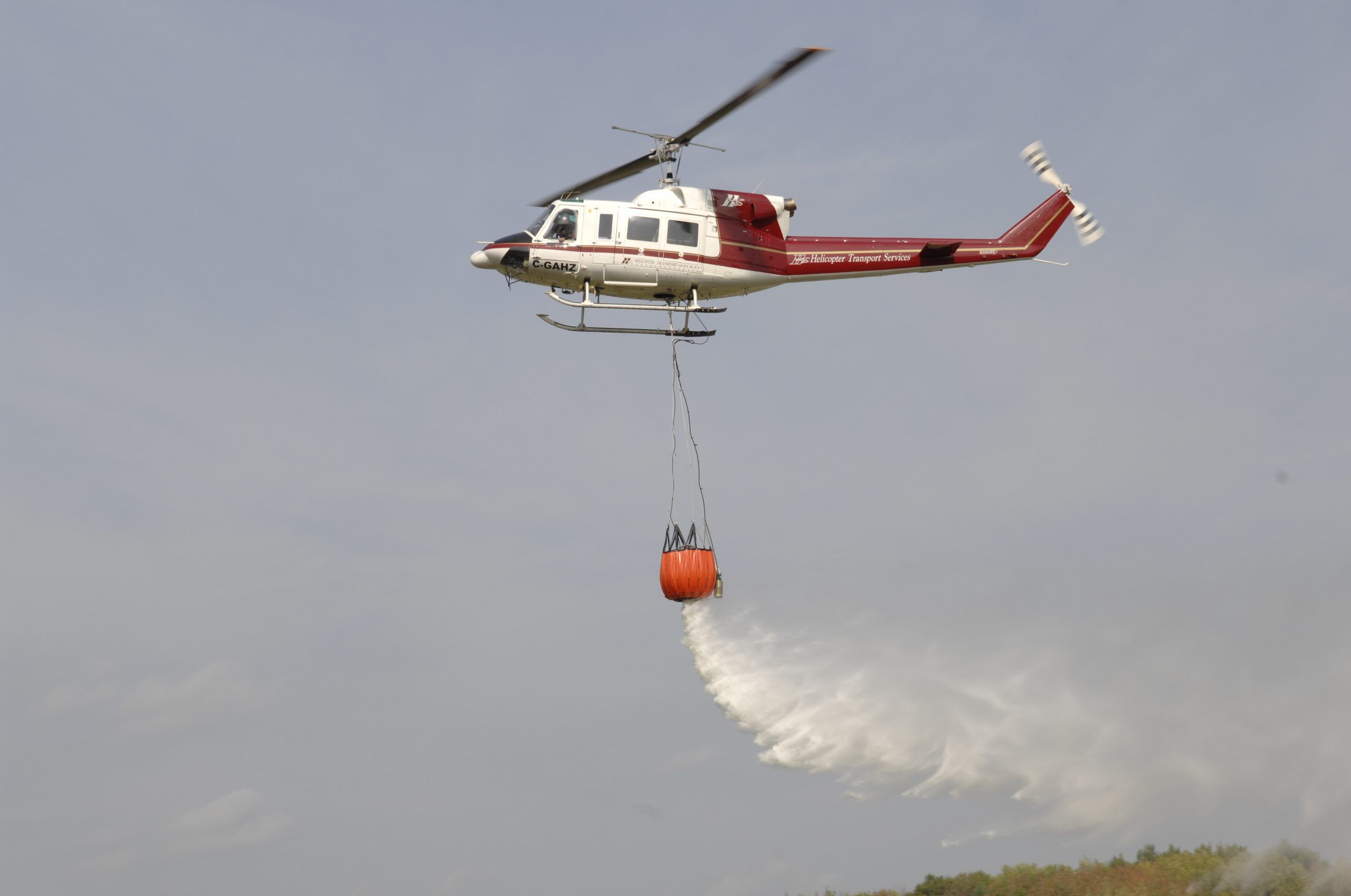HTS Bell 212 releasing water from a bucket on a long line