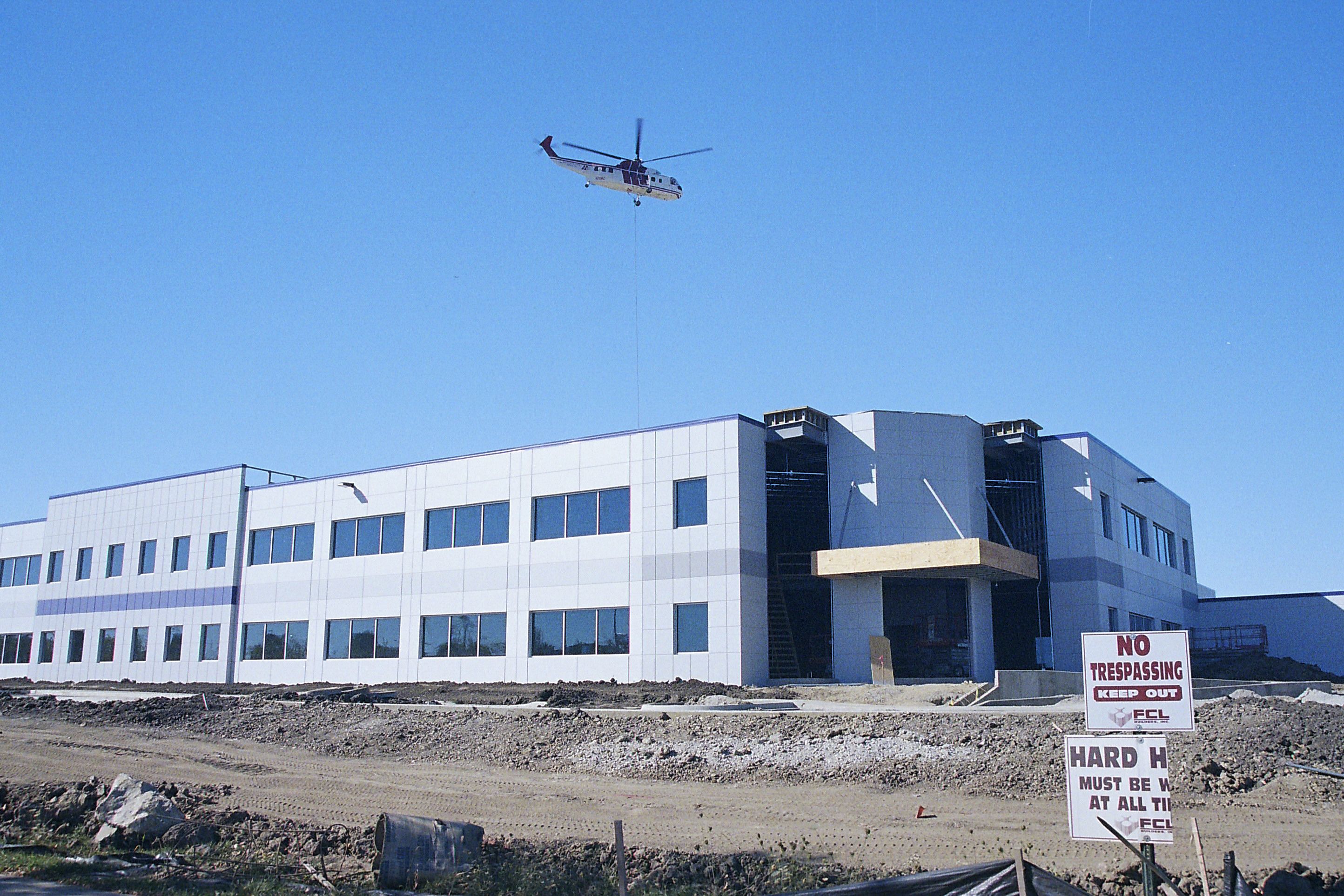 Helicopter working above a new industrial building