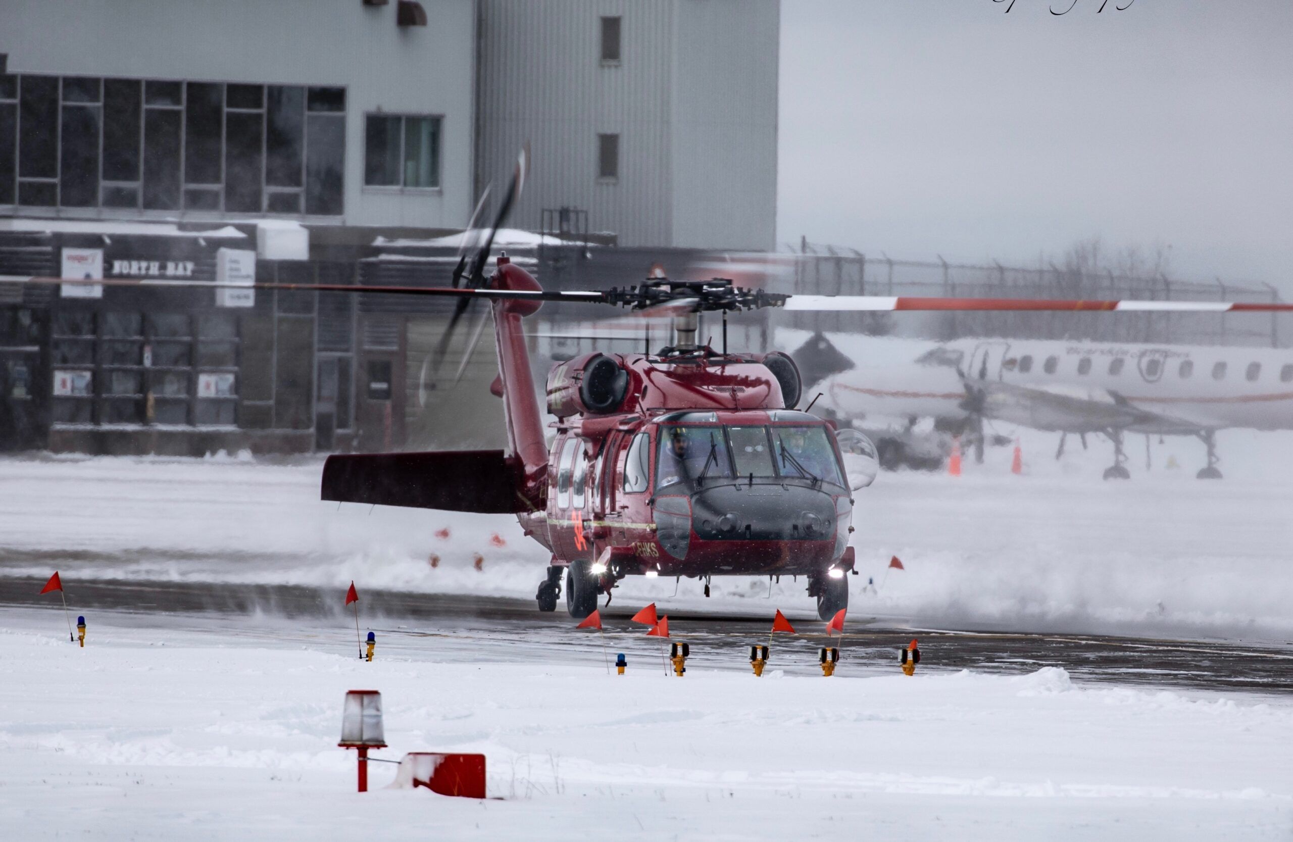 HTS Black Hawk lifting off from a snow-covered ramp