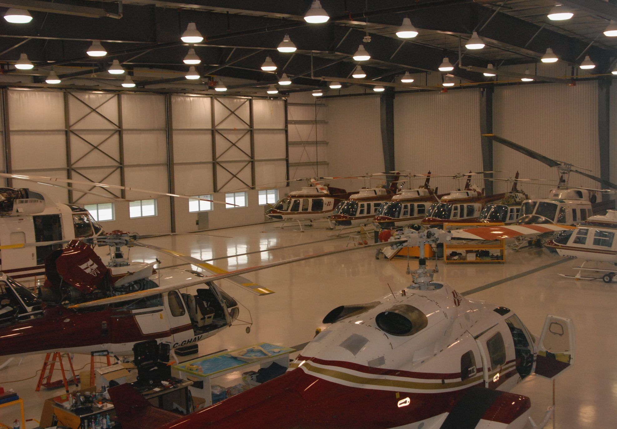 Inside the Carp hangar: Bell helicopters lined up under work lights
