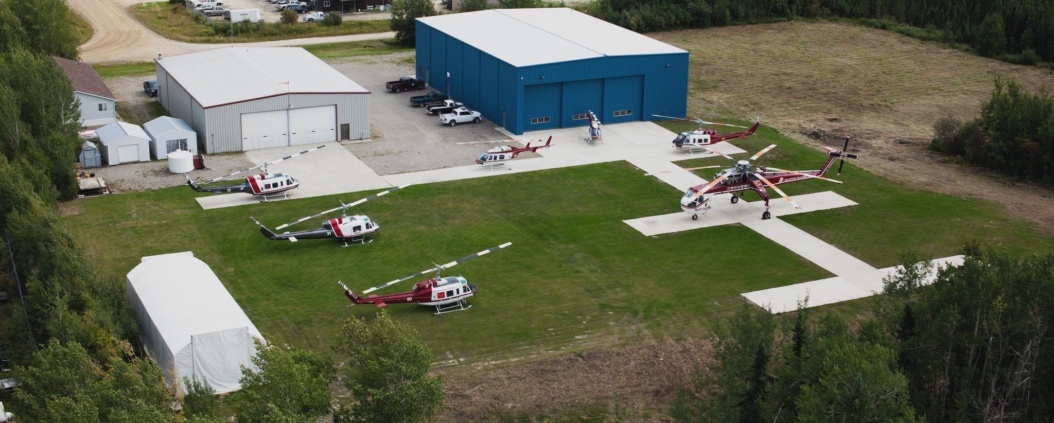 HTS La Ronge base from the air: a blue hangar, helipads and parked helicopters